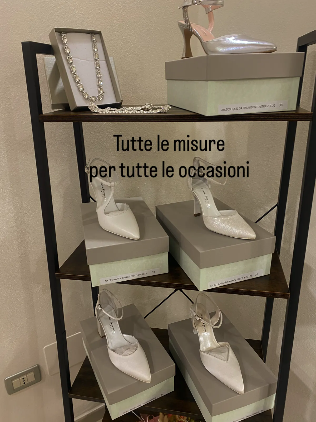 Scarpe da cerimonia eleganti su scaffale di legno con collana di cristalli